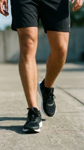 Legs in Black Shorts and Sneakers