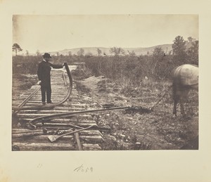 [Man holding bent rail]