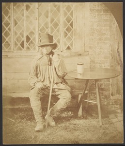 [Man seated at table]