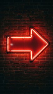 Neon Arrow Sign on Brick