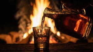 Pouring Moonshine by Firelight