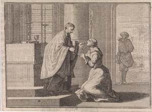 Priester geeft een voor het altaar knielende vrouw een hostie