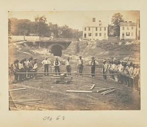 [Railroad construction workers straightening rails]