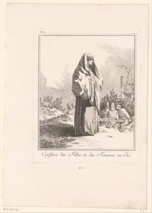 Staande vrouw met lange jurk en doek over haar hoofd