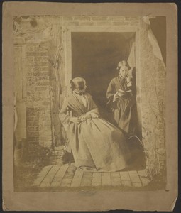 [Two young women in open doorway, one seated and one standing reading a book]