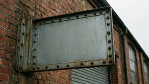 Weathered Metal Sign on Warehouse